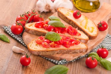 Fesleğen ve doğranmış domates Bruschetta ekmek. 