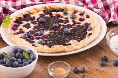 Beyaz çanak üzerinde üzümlü tart. 