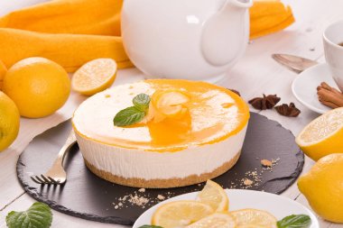 Ahşap masa üzerinde Limon Lor ile limon cheesecake.