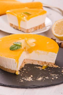 Ahşap masa üzerinde Limon Lor ile limon cheesecake.