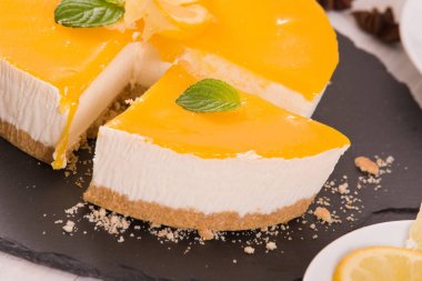 Limonlu cheesecake siyah çanak üzerinde. 