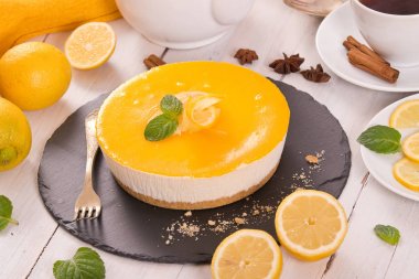 Limonlu cheesecake siyah çanak üzerinde. 
