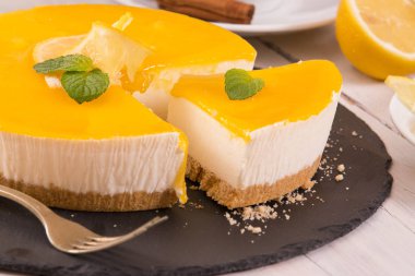 Limonlu cheesecake siyah çanak üzerinde. 