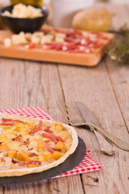 Kızarmış patatesli tart, raclette peyniri ve dumanlı pastırma..