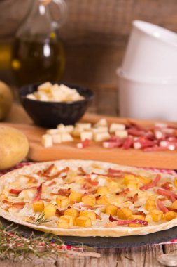 Kızarmış patatesli tart, raclette peyniri ve dumanlı pastırma..