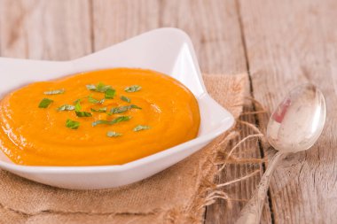 Beyaz tabakta balkabağı kremalı çorba.