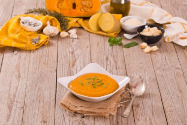 Beyaz tabakta balkabağı kremalı çorba.