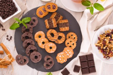 Kısa hamurlu hamur bisküvileri, üzerinde çikolata olan ahşap masa..