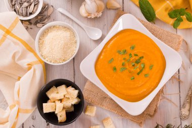 Beyaz tabakta balkabağı kremalı çorba.