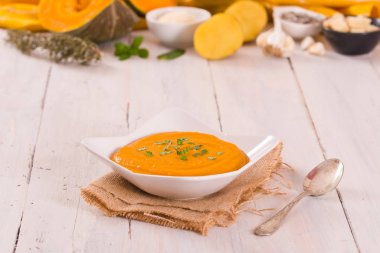 Beyaz tabakta balkabağı kremalı çorba.