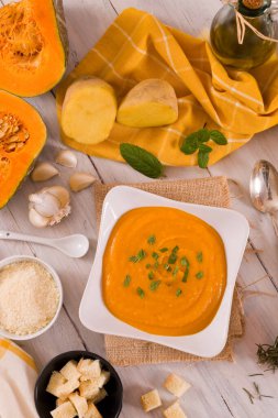 Beyaz tabakta balkabağı kremalı çorba.