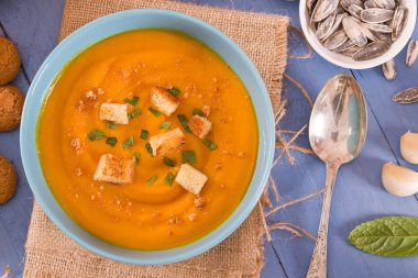 Tahta masadaki patatesli balkabağı kremalı çorba..