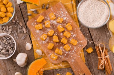 Kesme tahtasında patates olan çiğ balkabağı gnocchi..