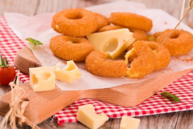 Kesme tahtasında kızarmış peynir halkası..