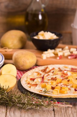 Kızarmış patatesli tart, raclette peyniri ve dumanlı pastırma..