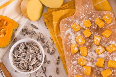 Kesme tahtasında patates olan çiğ balkabağı gnocchi..