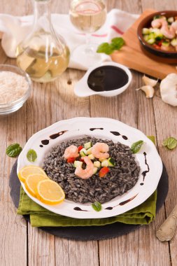 Beyaz tabakta sebzeli mürekkep balığı pilavı..