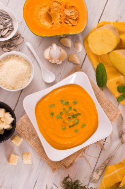 Beyaz tabakta patatesli balkabağı kremalı çorba.