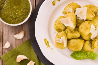 Beyaz tabakta pesto sosuyla doldurulmuş patates gnocchi..