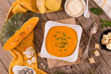 Beyaz tabakta patatesli balkabağı kremalı çorba.