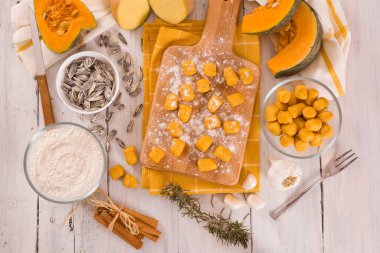 Kesme tahtasında patates olan çiğ balkabağı gnocchi..