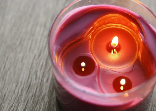 Drie paarse kaarsen op grijs houten tafel, bovenaanzicht — Stockfoto