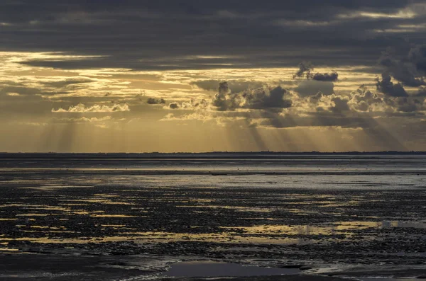 Luce del tramonto attraverso le nuvole dalla spiaggia, baia di Saint Mic — Foto Stock