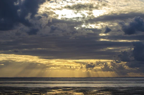 Sonnenuntergang Licht durch die Wolken vom Strand, Bucht von Saint Mic — Stockfoto