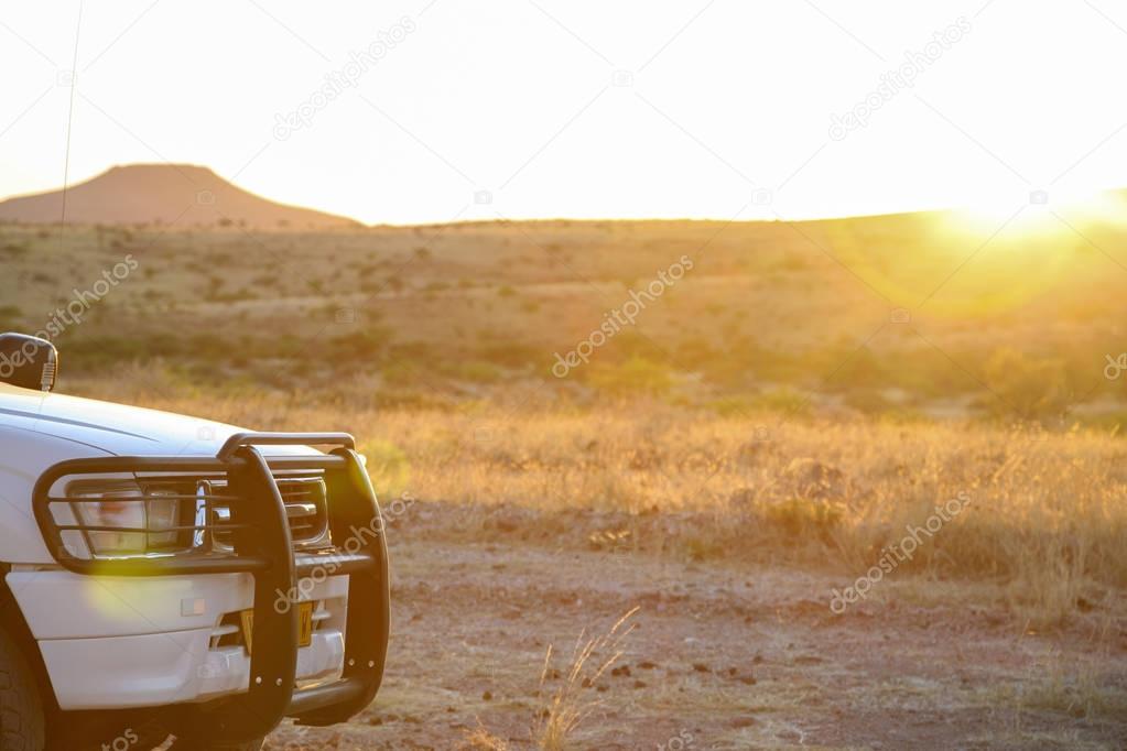 Bumper from 4x4 SUV with mountain and sunset in the background, 