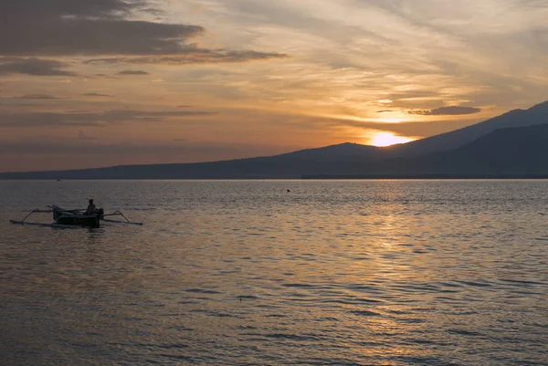 Tramonto con pescatore uomo pesca in una barca in mare vicino a Gili Air — Foto Stock