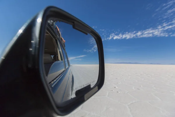 Espejo de coche con vista a los impresionantes pisos de sal de Uyuni con círculo —  Fotos de Stock