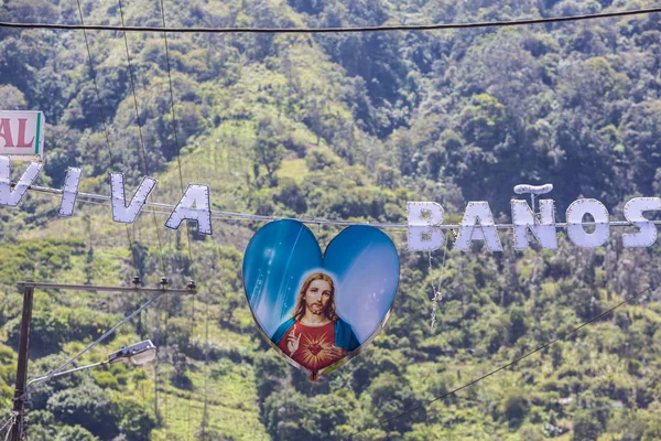Jesus sign suspended to a greeting sign in Banos, Ecuador — Stock Photo, Image
