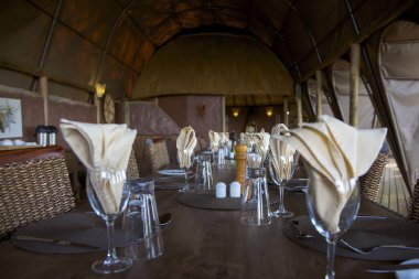 MoREMI NATURE RESERVE, BOTSwanA, JANUYARY 1: Moremi Doğa Koruma Alanındaki bir pansiyonda akşam yemeği için hazır güzel masa. Botswana 2010 (Seçici odak)