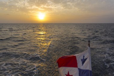 Panama Bayrağı, San Blas Adaları 'nda gün batımında ufuk ve deniz ile dalgalanıyor. Panama.