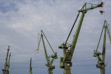 Polonya 'nın Gdansk kentindeki tersanelerde sanayi manzaralı büyük vinçler.
