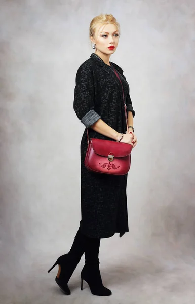 Vrouw in donkere jas en tas — Stockfoto