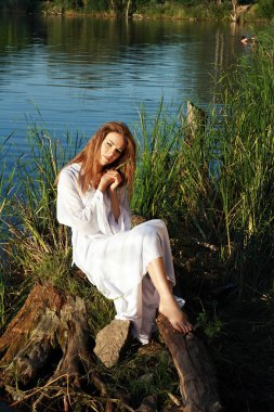 Göl kıyısındaki oturan kadın