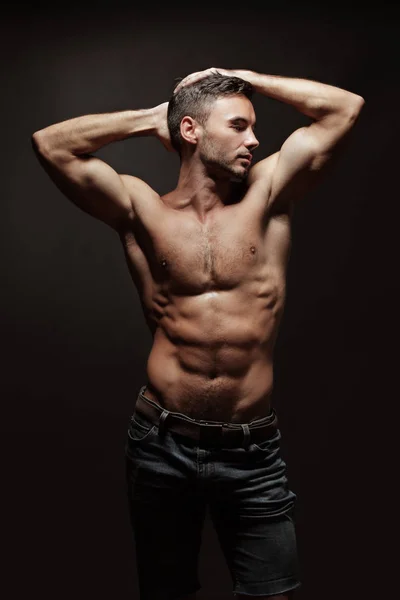 Athletic man showing muscles — Stock Photo, Image