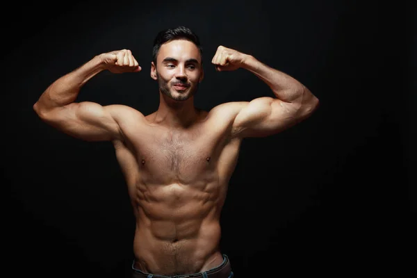 Athletic man showing muscles — Stock Photo, Image