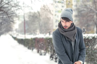 Kışın parkta yürüyen genç adam