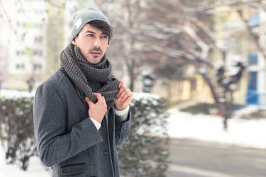 Kışın parkta yürüyen genç adam