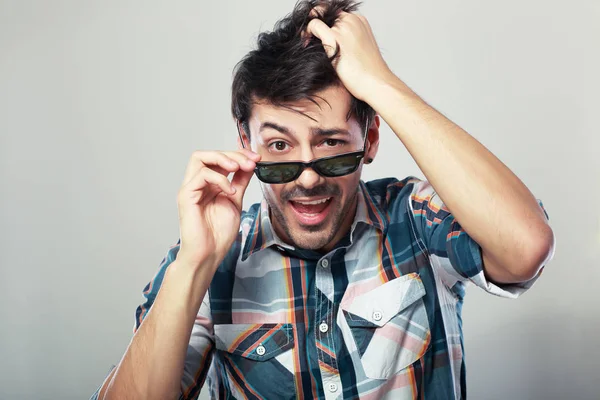 Man kijkt uit over de glazen op camera — Stockfoto