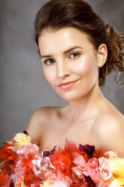 Vrouw in jurk van bloemen glimlachend op camera — Stockfoto