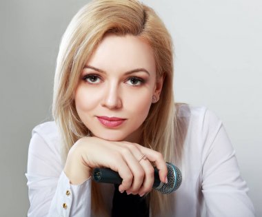 elinde mikrofon ile oturan güzel glamour şık kadın portresi