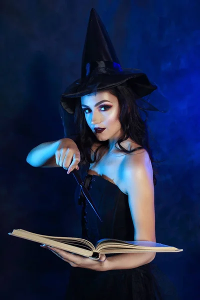 half length portrait of beautifull young woman in witch dress holding magic wand