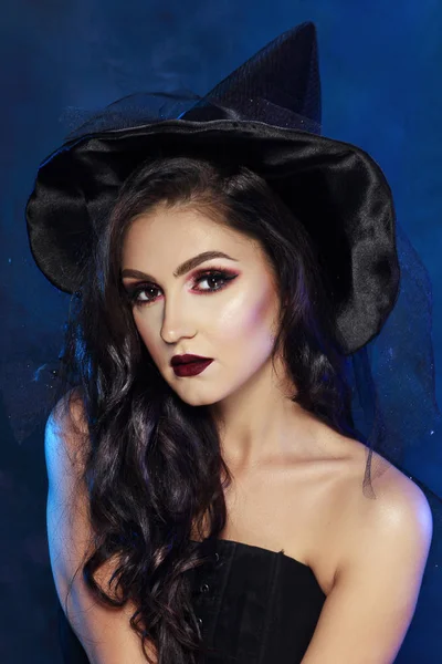 魔女のドレスと帽子の美しい若い女性の肖像画 — ストック写真