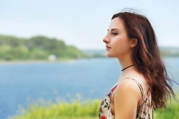 湖のそばの美しい若い女性の横顔の肖像画 — ストック写真