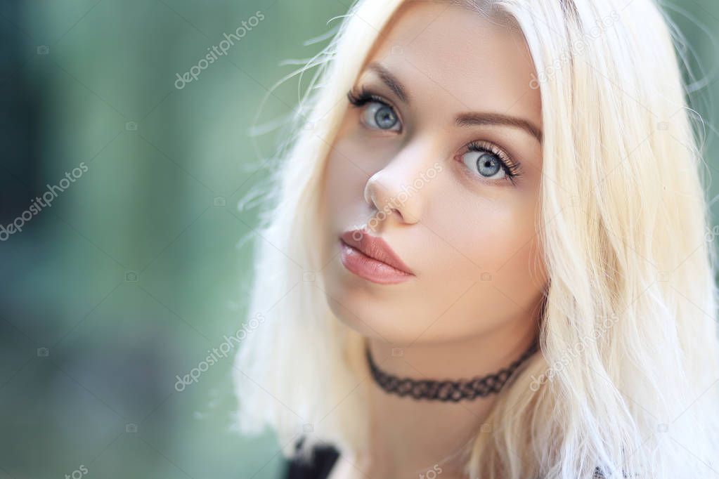blond glamour woman outdoor looking at camera 