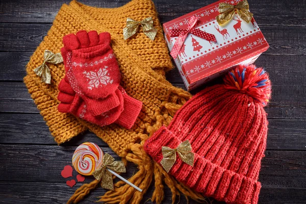Rode muts en handschoenen, gele sjaal Kerst ornamenten op de houten achtergrond — Stockfoto