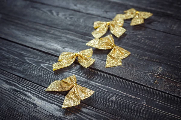 Feestelijke pack van vijf gouden boog liggend op de houten achtergrond — Stockfoto
